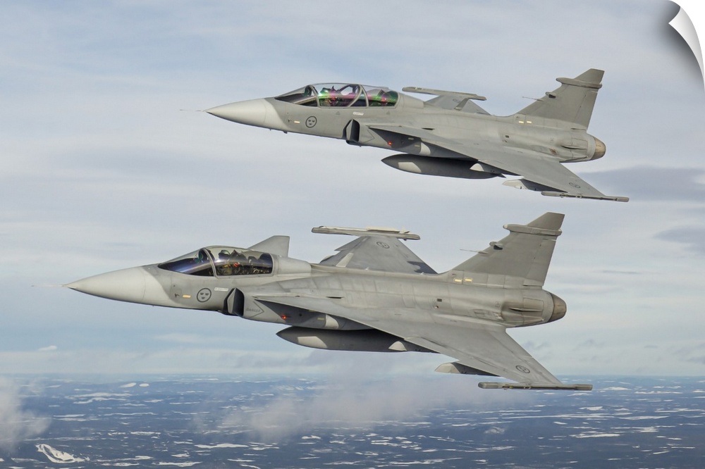 A pair of Swedish Air Force JAS-39 Gripen fighter jets in flight over northern Sweden.
