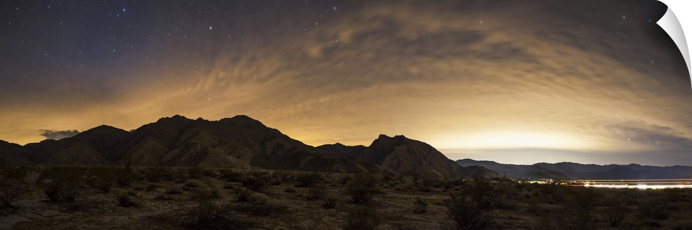A partly coiudy sky over Borrego Springs reflects lights from the surrounding desert cities in California.