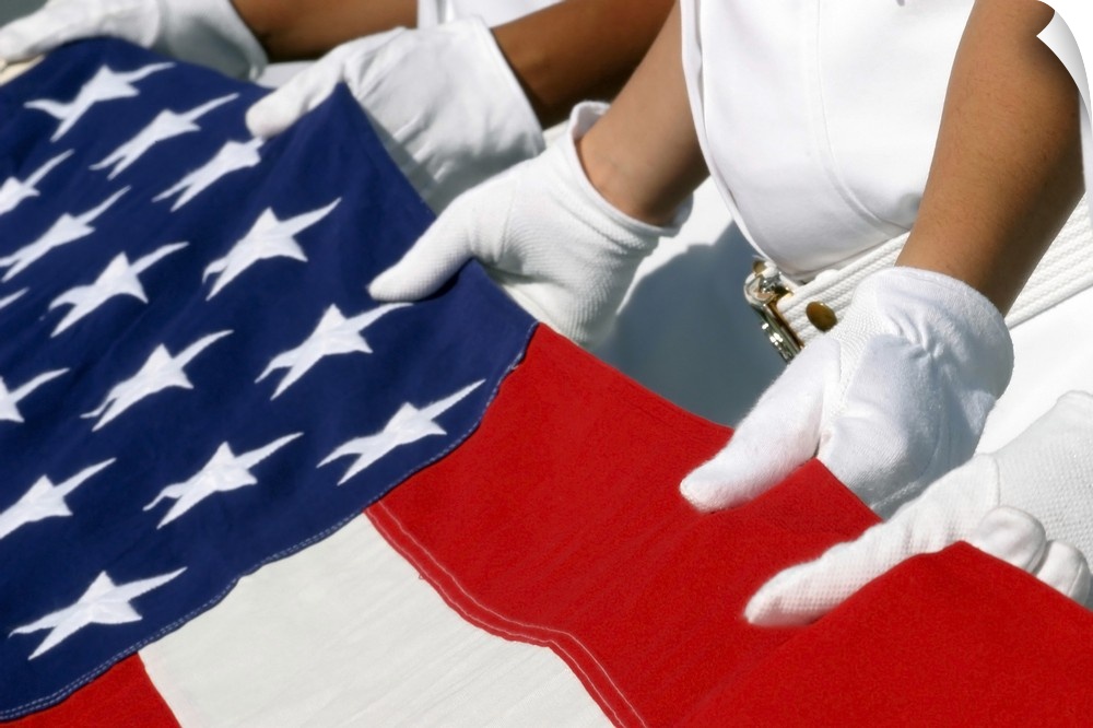 A Naval Station Pearl Harbor Ceremonial Guard folds the National Ensign during a burial ceremony.