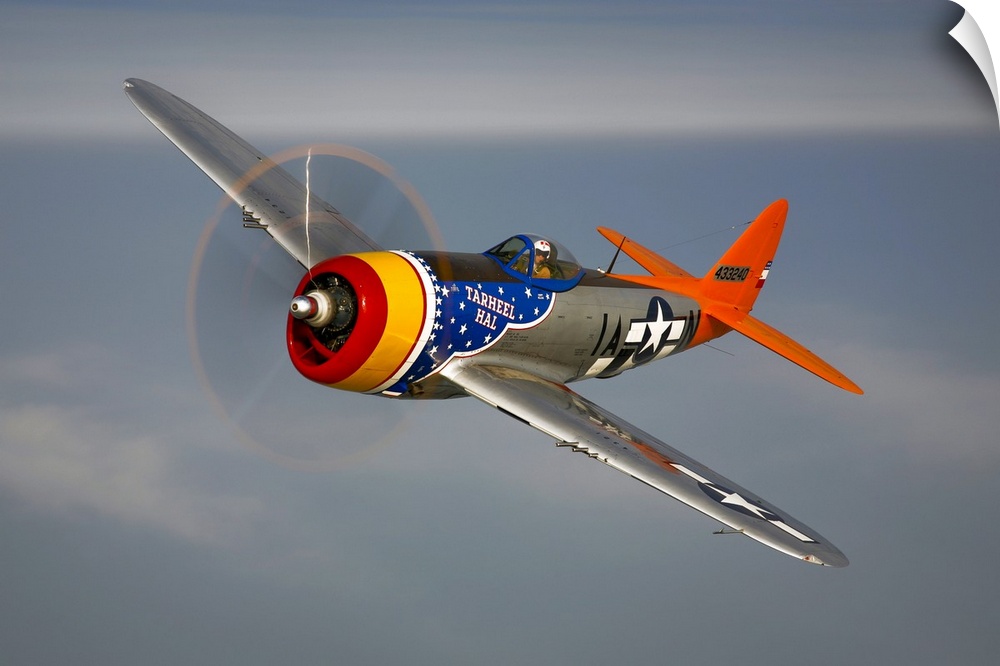 A Republic P-47D Thunderbolt in flight over Galveston, Texas. This vintage propeller plane is brightly painted.