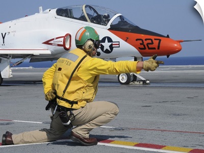 A shooter signlas the launch of a T-45A Goshawk trainer aircraft