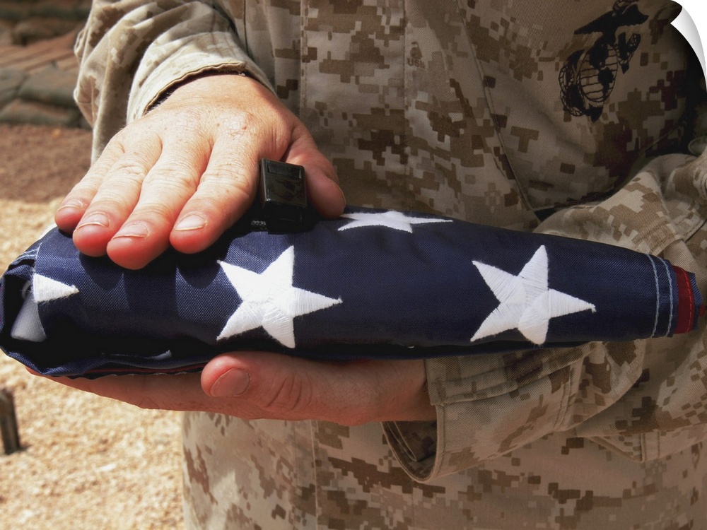 A soldier holds the United States flag.