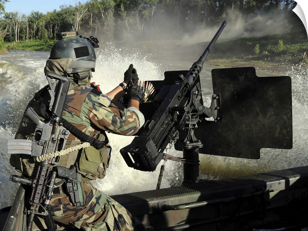 A Special Warfare Combatantcraft Crewman reloading an M2 Heavy Barrel machine gun