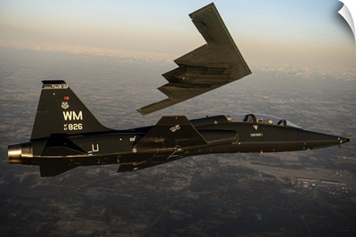 A T-38 Talon flies in formation with a B-2 Spirit
