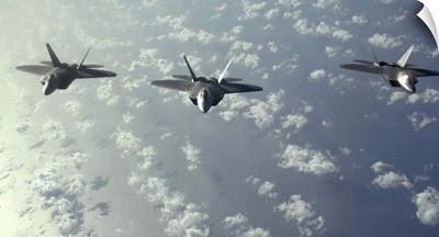 A threeship formation of F22 Raptors fly over the Pacific Ocean