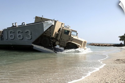 A truck offloads from a landing craft unit
