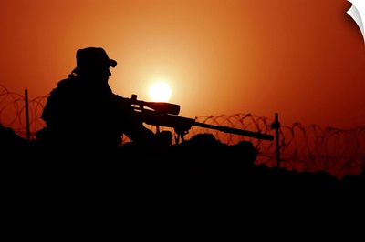 A U.S. Special Forces soldier armed with a Mk-12 Sniper Rifle at sunset