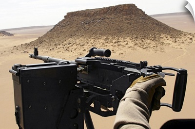 A UH60 Blackhawk crew chief holds an M240G medium machine