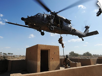 A US Air Force Pararescuemen fast ropes from an HH60 Pavehawk helicopter