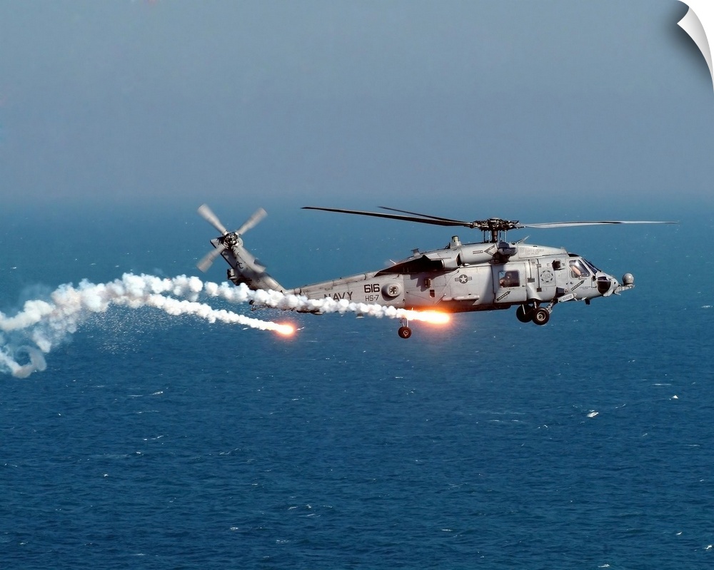 A U.S. Navy HH-60H Seahawk Helicopter dispenses flares and chaff as it tests the onboard AN/AAR-47 Missile Warning System,...