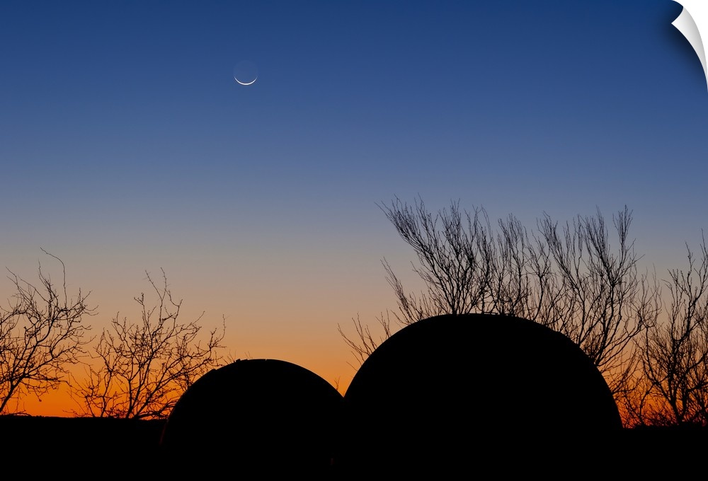Two domed observatories await the darkness of night as the young moon sets. Taken at the 3RF Astronomy Campus near Crowell...