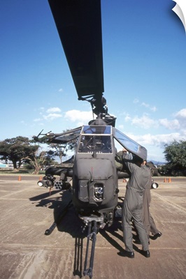 Air crewmen secure an AH1 Cobra attack helicopter