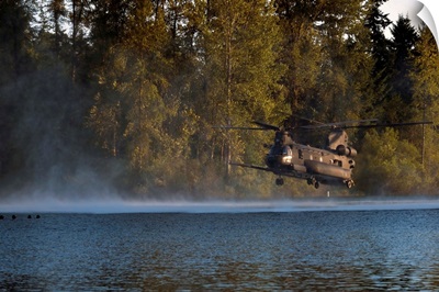 Airmen wait in a lake for an MH-47 Chinook helicopter to extract them