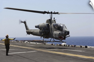 An AH-1W Super Cobra takes off from the flight deck of USS Kearsarge