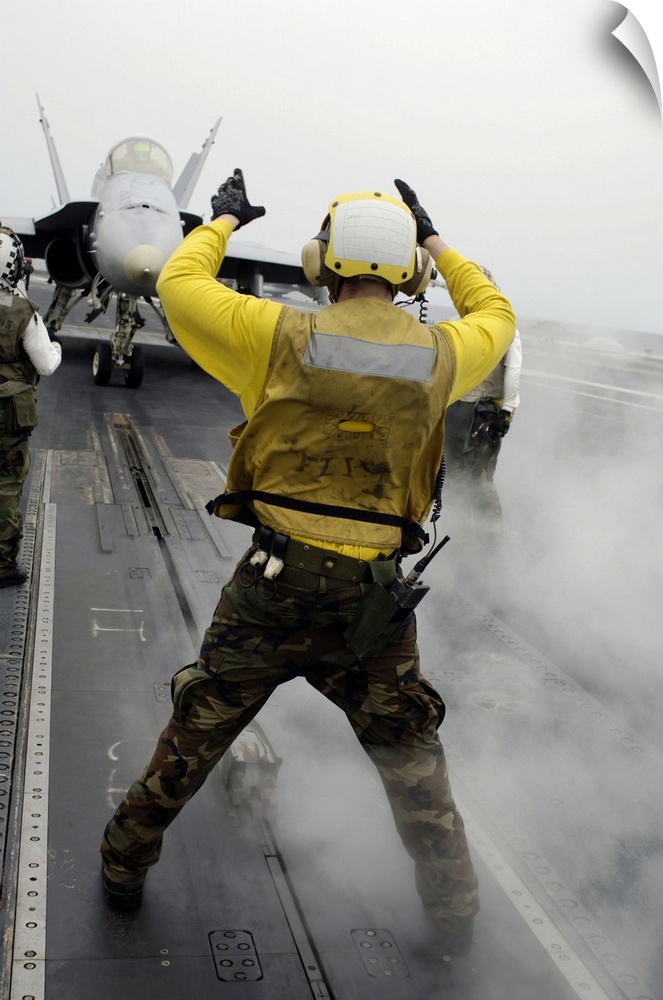 Pacific Ocean, April 16, 2008 - An aircraft director signals an F/A-18C Hornet from taxi to launching position on the flig...