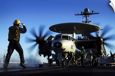 An Airman guides an E2C Hawkeye