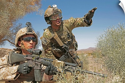 An Army soldier informs a Marine on the current situation while providing security