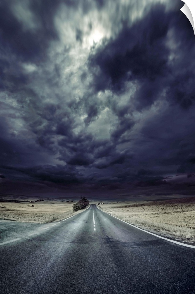 An asphalt road with stormy sky above, Tuscany, Italy.