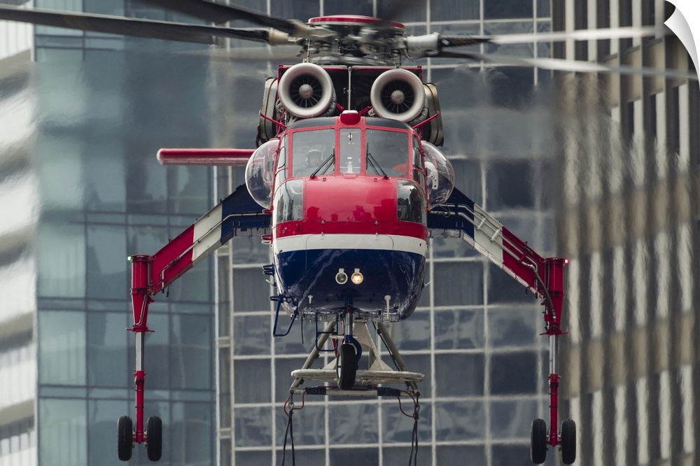 An Erickson Aircrane S-64 Aircrane hovers over a load, ready to lift it to the top of a building in Chicago, Illinois.