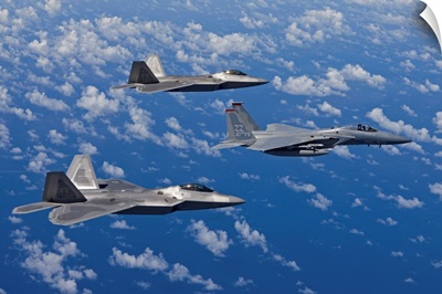 An F-15 Eagle and two F-22 Raptors fly in formation over Japan