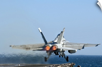 An F/A-18F Super Hornet launches from the flight deck of aircraft carrier USS Nimitz
