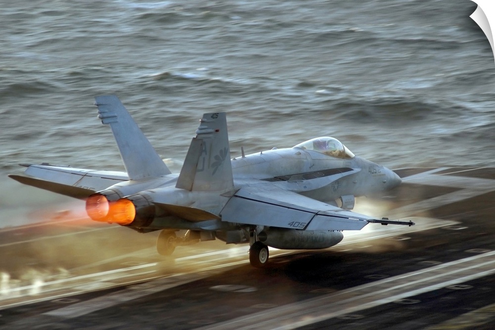 Up-close photograph of jet taking off of an air craft carrier in the ocean.