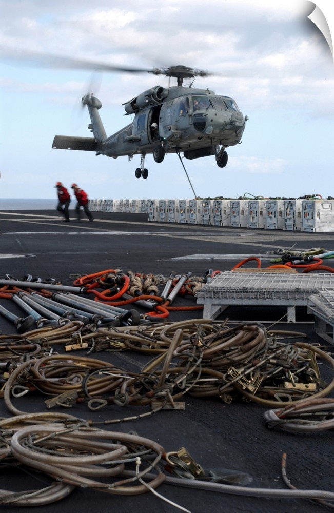 An HH-60H Seahawk helicopter prepares to lift a crate of ordnance.