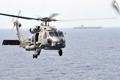 An MH-60R Seahawk helicopter in flight over the Pacific Ocean