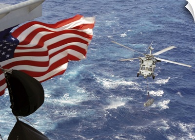 An MH-60S Sea Hawk carries supplies during a replenishment at sea