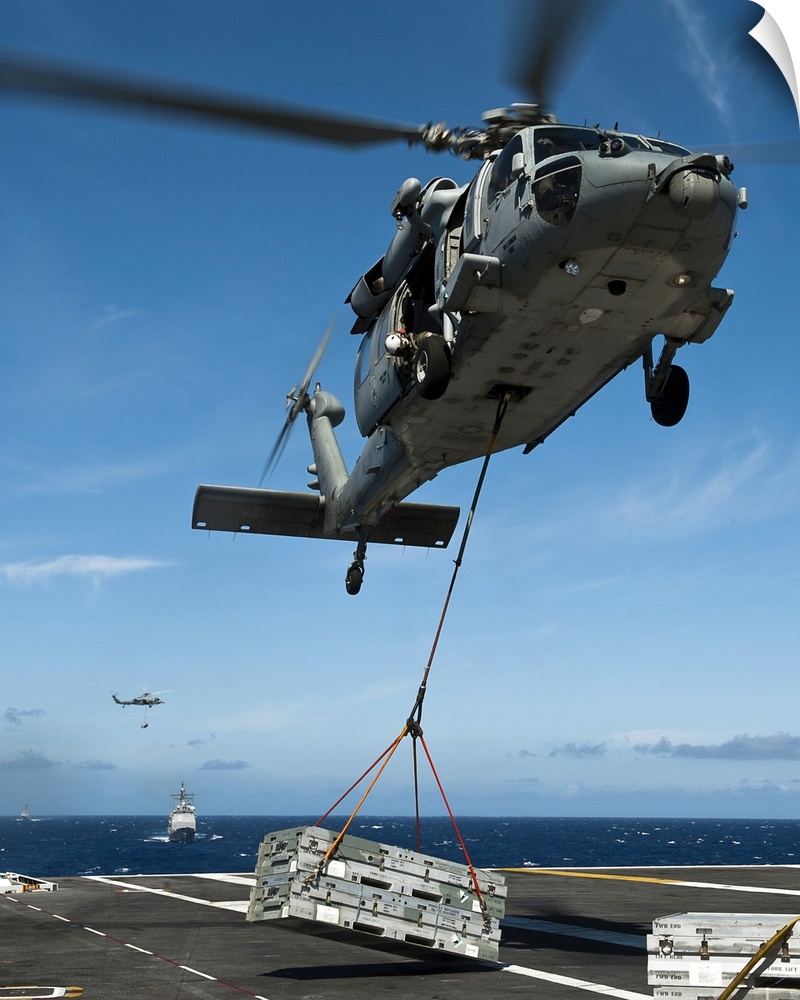 Pacific Ocean, August 7, 2011 - An MH-60S Sea Hawk helicopter lowers cargo onto the deck of the Nimitz-class aircraft carr...