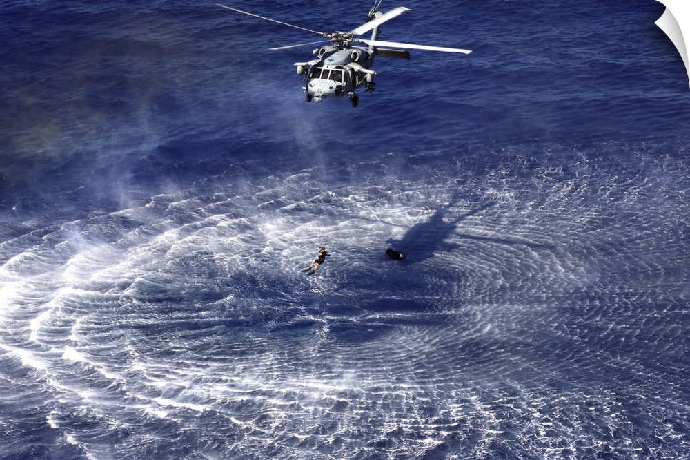 December 11, 2013 - An MH-60S Seahawk lowers a rescue swimmer into the water as part of a simulated combat search and resc...
