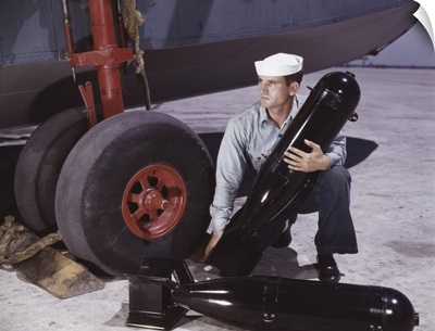 August 1942 - Sailor picking up a bomb at Naval Air Base, Corpus Christi, Texas.