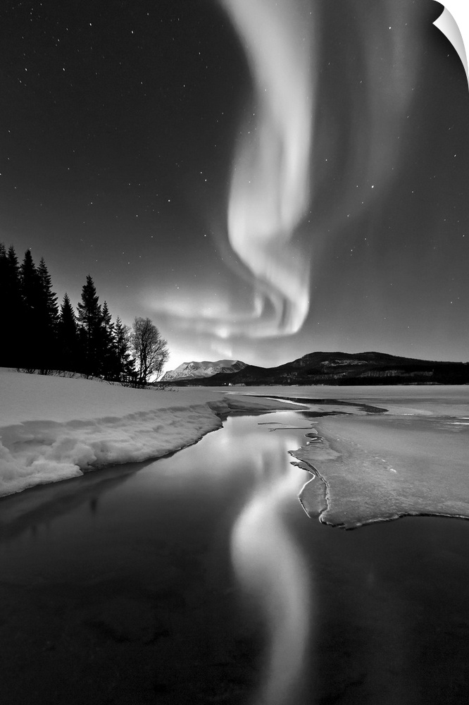 Aurora Borealis over Sandvannet Lake in Troms County, Norway. Auroras are the result of the emissions of photons in the Ea...