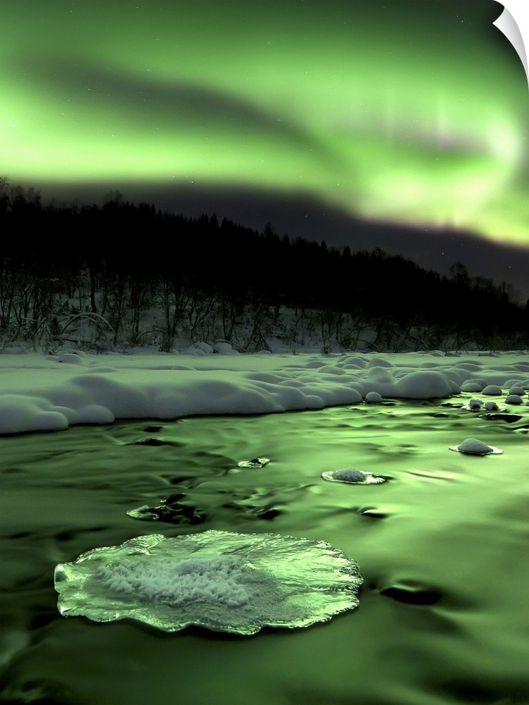 Aurora Borealis reflects off the Tennevik River, Troms County, Norway. Auroras are the result of the emissions of photons ...
