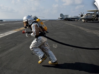 Aviation Boatswain'S Mate Carries A Fire Hose During A Fire Drill
