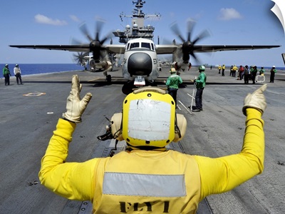 Aviation Boatswain's Mate Directs A C-2A Greyhound Onto A Catapult