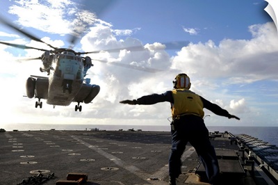 Aviation Boatswains Mate directs a CH 53E Super Stallion