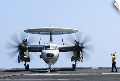 Aviation Boatswain's Mate directs an E-2C Hawkeye on the flight deck
