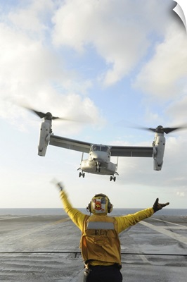Aviation Boatswain's Mate Signals An MV-22 Osprey To Land