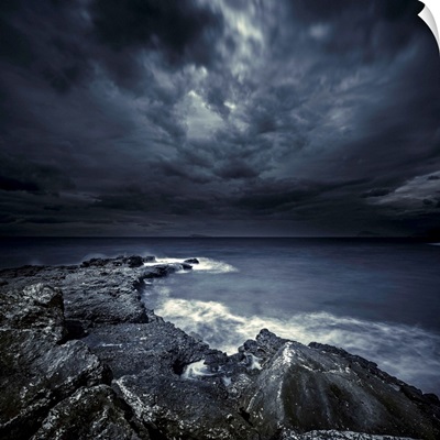 Black rocks protruding through rough seas with stormy clouds, Crete, Greece