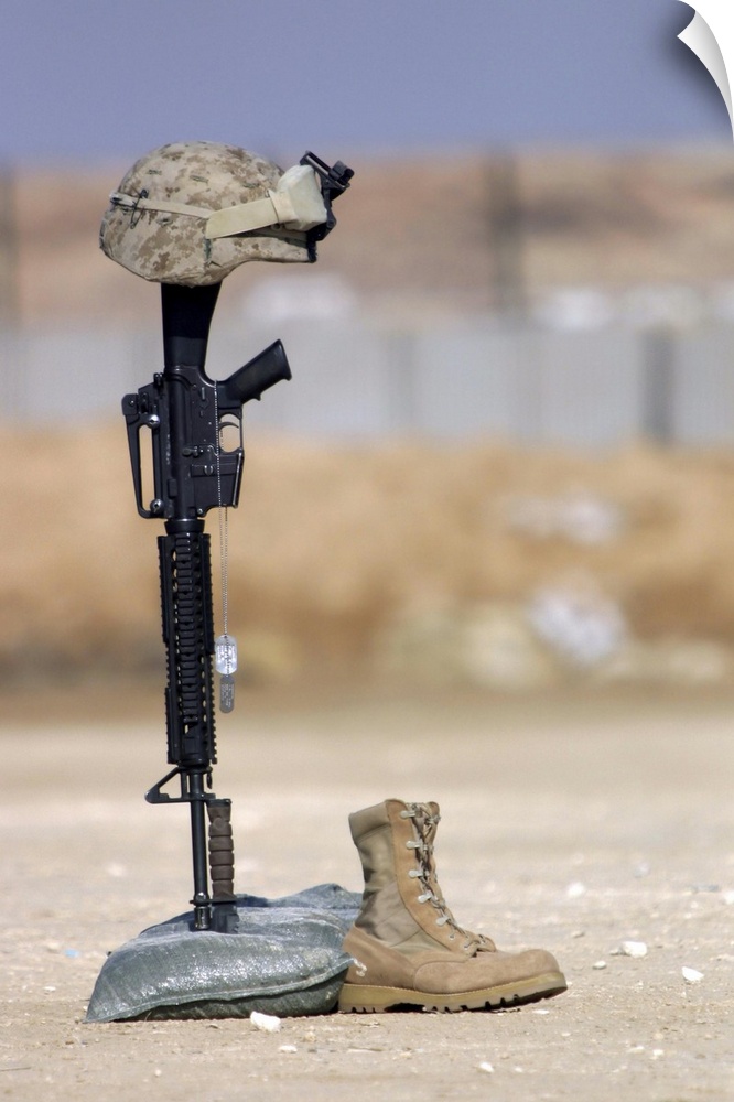 Boots, rifle, dog tags, and protective helmet stand in solitude to honor fallen soldiers.