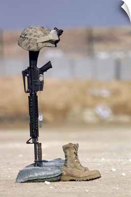 Boots, rifle, dog tags, and protective helmet stand in solitude to honor fallen soldiers