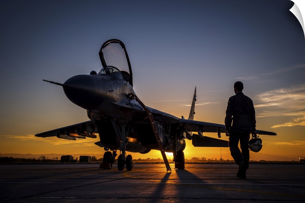 Pilot walking to a Bulgarian Air Force MiG-29 during sunset at Graf Ignatievo Air Base, Bulgaria, for a night mission sortie.