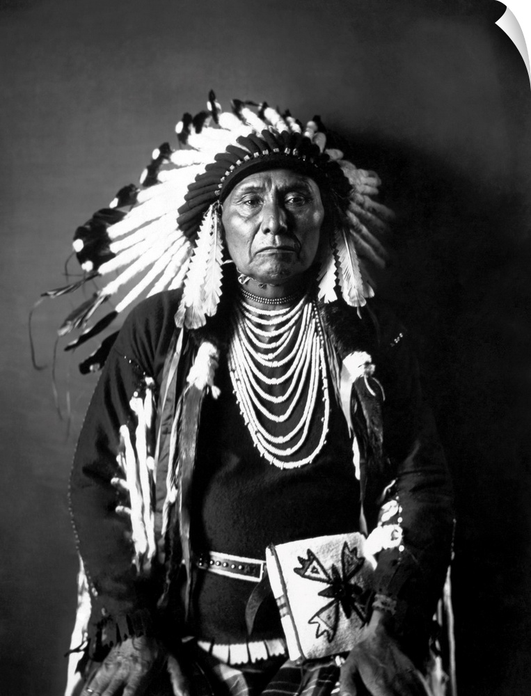 Chief Joseph of the Nez Perce tribe in a black and white seated portrait in full traditional tribal dress. Taken in 1900, ...