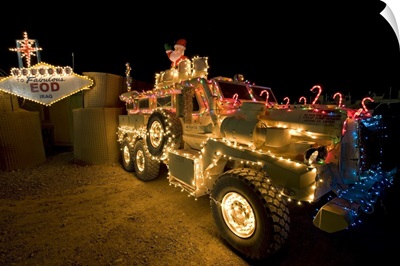 Cougar MRAP is adorned in holiday lights parked in front of EOD Iraq