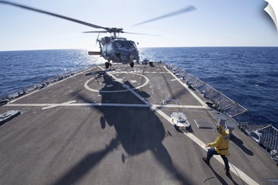 Cryptologic Technician directs an SH-60R Sea Hawk helicopter