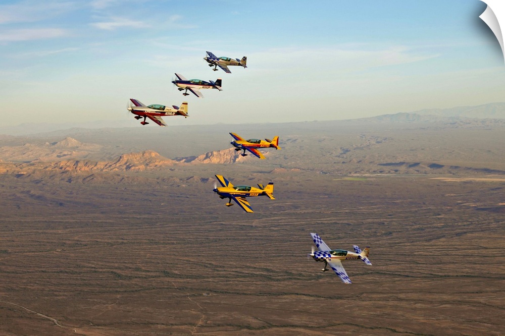 Extra 300 aerobatic aircraft fly in formation during APS training in Mesa, Arizona.