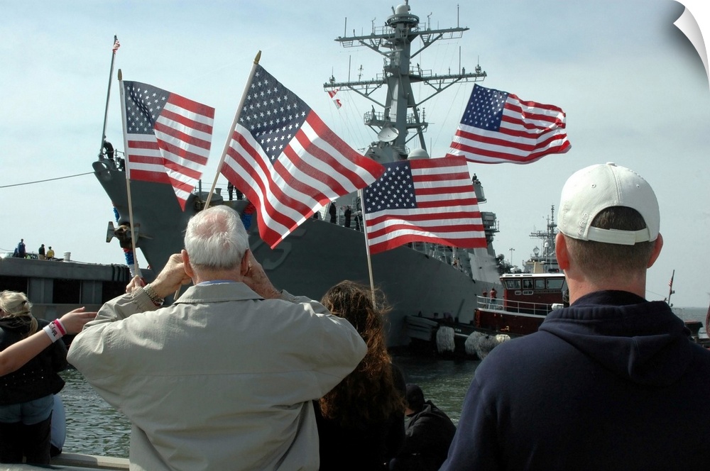Norfolk, Virginia, March 9, 2006 - Family members wave American flags as they anxiously await their loved ones aboard the ...
