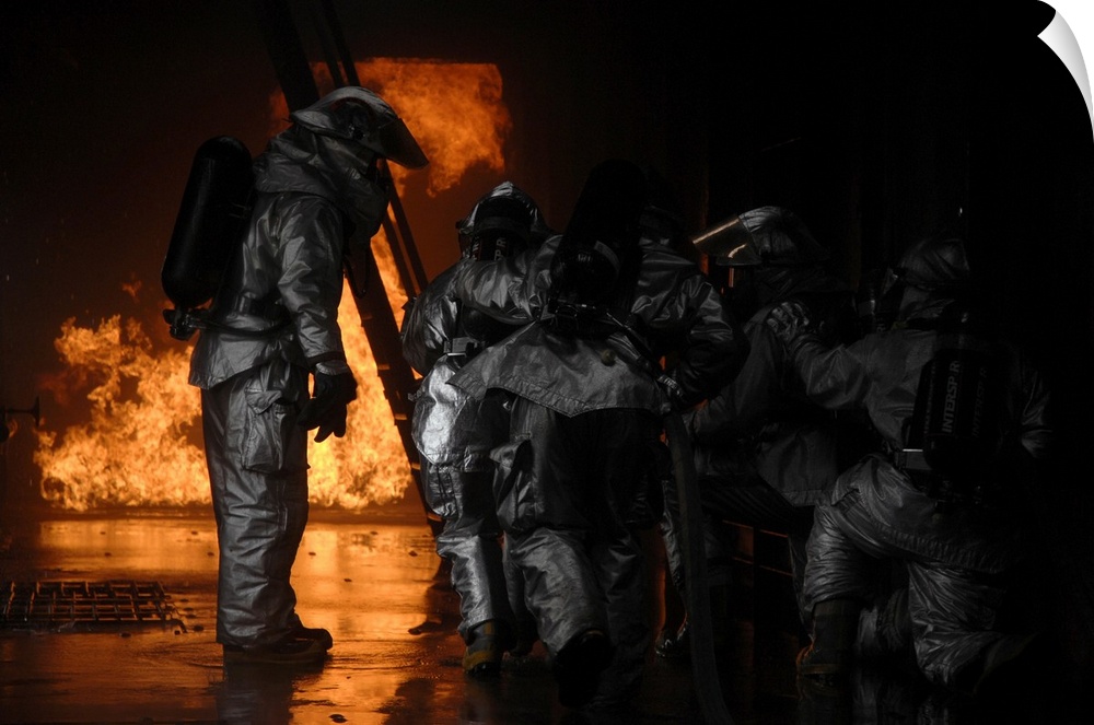 March 8, 2008 - A 48th Civil Engineer Squadron firefighter instructs fellow firefighters to advance towards the simulated ...