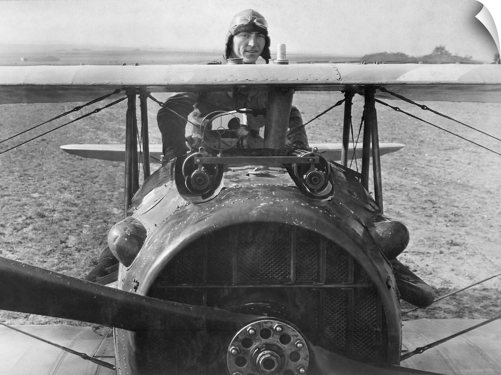 First Lieutenant Eddie Rickenbacker standing on his Spad biplane in France, 1918.